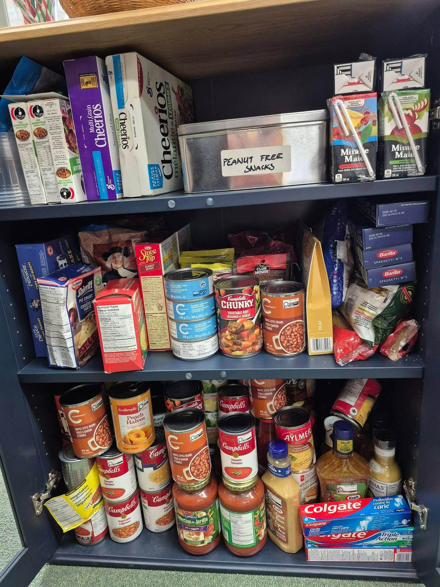 Pantry cabinet stocked with canned goods and snacks